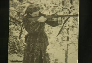 “Here I am, Faye Schulman, practicing how to aim. You can see I have here already an Automat, a ‘papasha.’ In the right, I have a gun, and I have a grenade. And no more a plain rifle, because I volunteered [to go] on every attack. So they thought that I deserved to have an Automat, that with one trigger pull, it would shoot 66 bullets.”