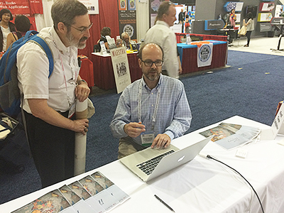 Ballman assists a visitor at the USC Shoah Foundation table