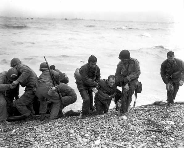 Members of a landing party help injured Soldiers to safety on Utah Beach during the Allied Invasion of Europe on D-Day, June 6, 1944.