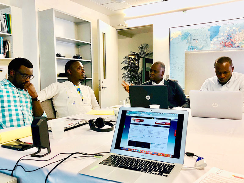 Members of the education team from Aegis Trust discuss creating IWitness activities that feature the testimonies from survivors and witnesses to the Genocide against the Tutsi in Rwanda. From left to right: Enoch Ssemuwemba, Pierre Claver Irakoze, Jean Nepo Ndahimana and Marc Gwamaka.
