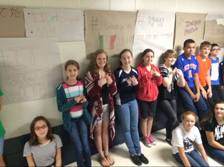 Students from Lauren Fenech and Steffanie Grotz’s class in front of their student constructed #BeginsWithMe banners, written in the 10 most popular languages around the world.