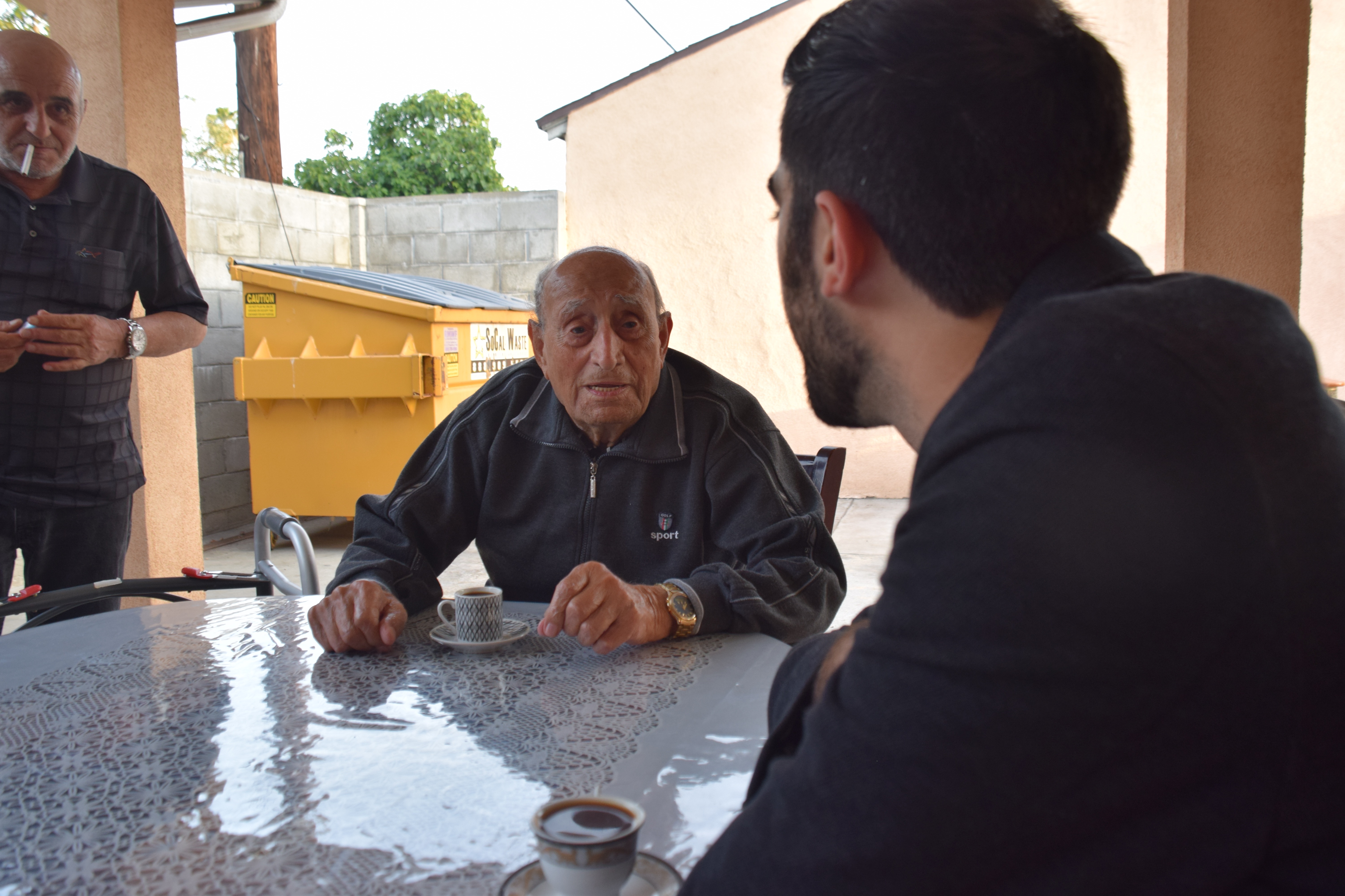 Agop Margarian (standing), Aleksan Markaryan chats with Manuk Avedikyan
