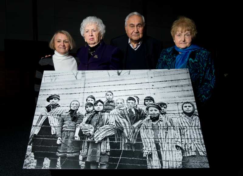 (L-R) Paula Lebovics, Miriam Ziegler, Gabor Hirsch and Eva Kor pose with the original image of them as children taken at Auschwitz at the time of its liberation on January 26, 2015 in Krakow, Poland. 