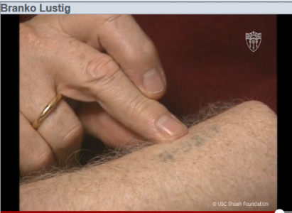 Branko Lustig shows his arm tattoo from Auschwitz.