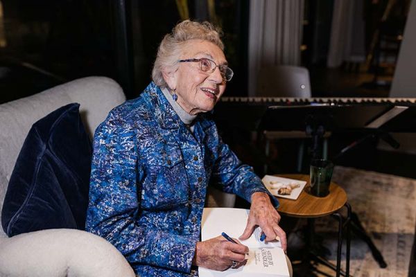 Celina Biniaz signing her biography, "Saved by Schindler: The Life of Celina Karp Biniaz." Photo credit: Tori Time/DWMA