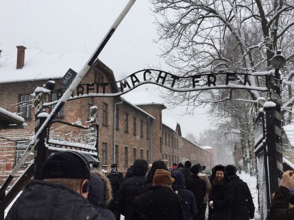 Our tour group walks underneath the infamous gate at Auschwitz I. Our tour group walks underneath the infamous gate at Auschwitz I.