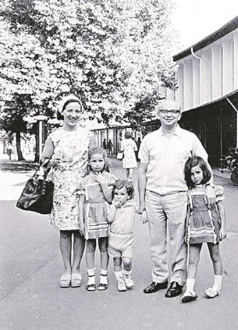 Noemie Lopian as a little girl standing next to her mother in a family photo.